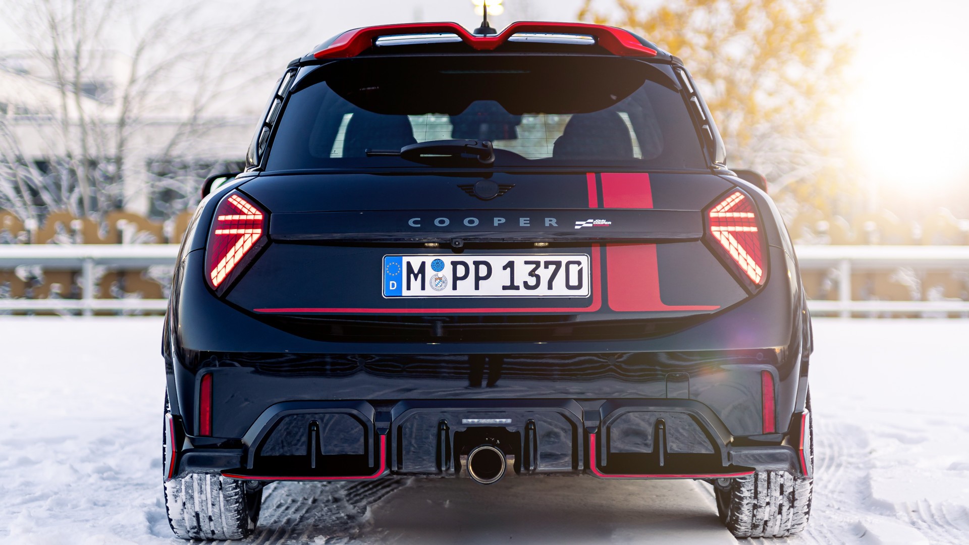 MINI Cooper 3-Türer mit MINI John Cooper Works Aufklebern in Chili Red in der Heckansicht.